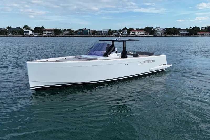 Slide: The Image of 2019 Fjord 40' Open yacht cruising on calm waters near a coastal neighborhood. - 2