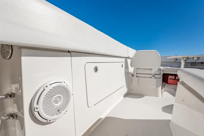 Slide: The Image of 2019 Jupiter 38 HFS boat interior with seating and speaker, under clear blue sky. - 14