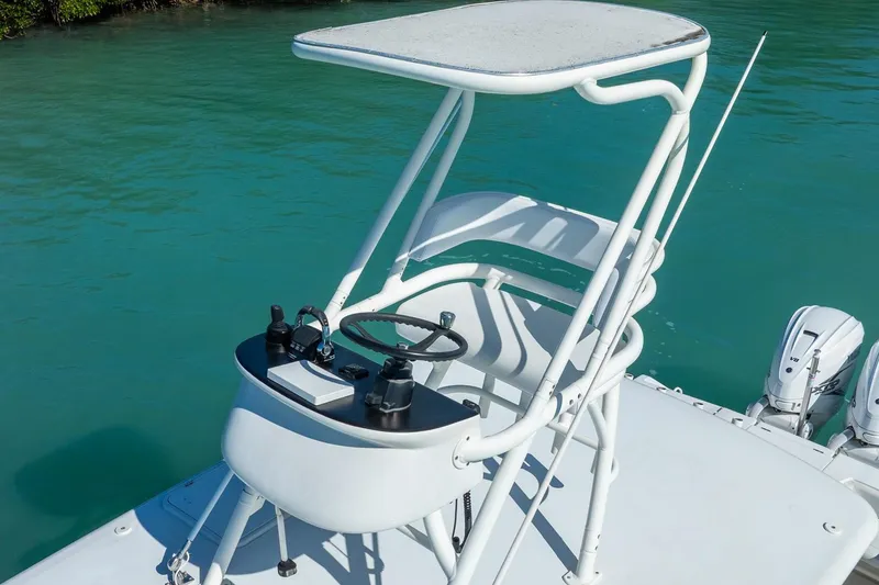 Slide: The Image of 2019 Jupiter 38 HFS boat helm station with steering wheel and controls on turquoise water. - 17