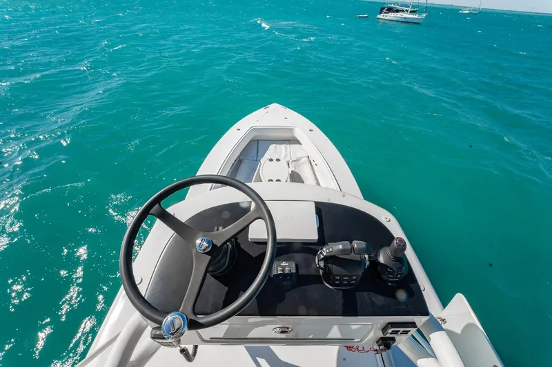 Slide: The Image of 2019 Jupiter 38 HFS boat steering console on turquoise ocean waters. - 18