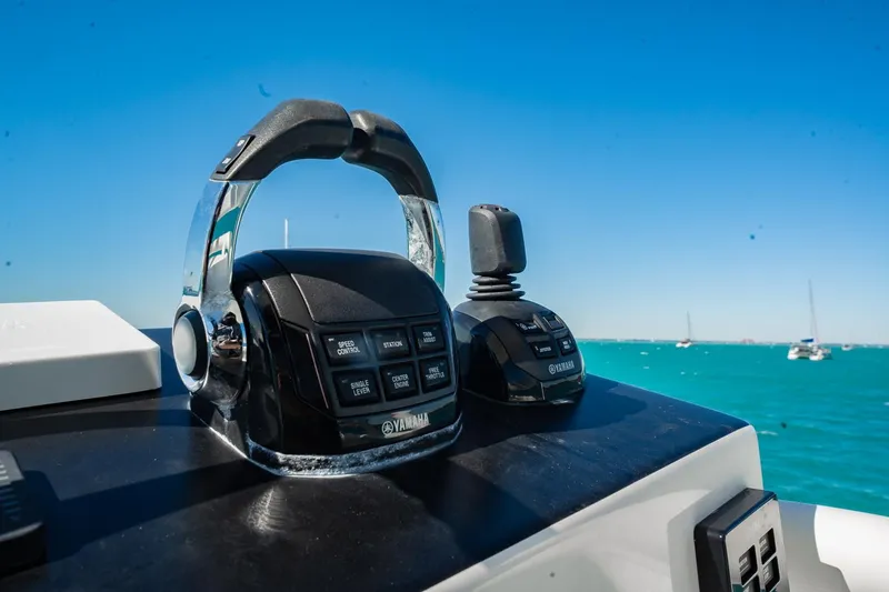 Slide: The Image of Yamaha controls on a 2019 Jupiter 38 HFS boat, with ocean and sailboats in background. - 19