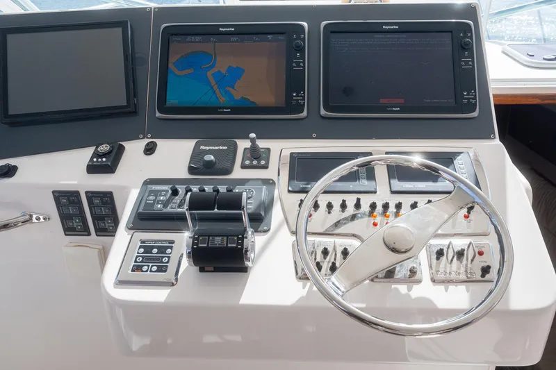 Slide: The Image of Control panel of a 2019 Jupiter 38 HFS boat with navigation screens and steering wheel. - 28