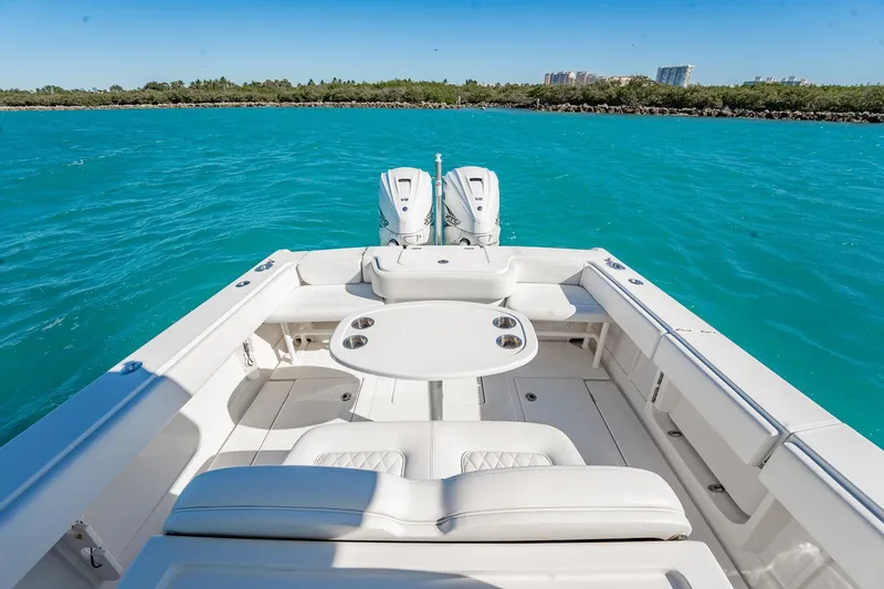 Slide: The Image of 2019 Jupiter 38 HFS boat with dual engines on turquoise water, featuring a spacious seating area. - 33