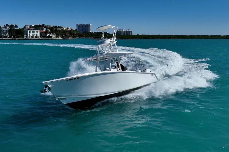 Slide: The Image of 2019 Jupiter 38 HFS boat cruising on turquoise water near a coastal city. - 46