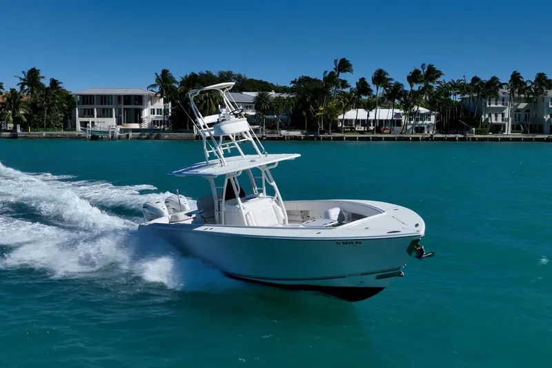 Slide: The Image of 2019 Jupiter 38 HFS boat cruising on turquoise water near palm-lined shore. - 49