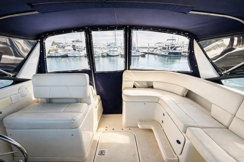 Slide: The Image of Interior of 1997 Tiara 3100 Open Express yacht with white seating and marina view. - 13