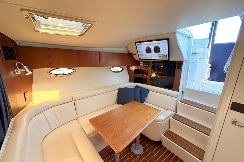 Slide: The Image of 1997 Tiara 3100 Open Express cabin interior with seating, table, and stairs. - 14