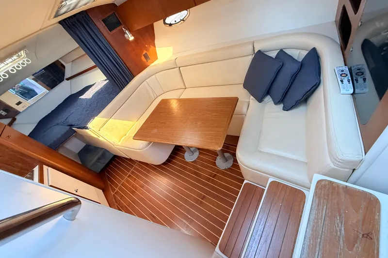 Slide: The Image of Interior of a 1997 Tiara 3100 Open Express yacht with cozy seating and wooden table. - 15