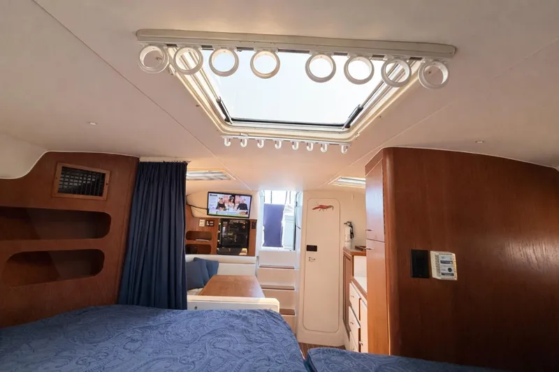 Slide: The Image of Interior of a 1997 Tiara 3100 Open Express yacht, featuring cozy cabin and skylight. - 18