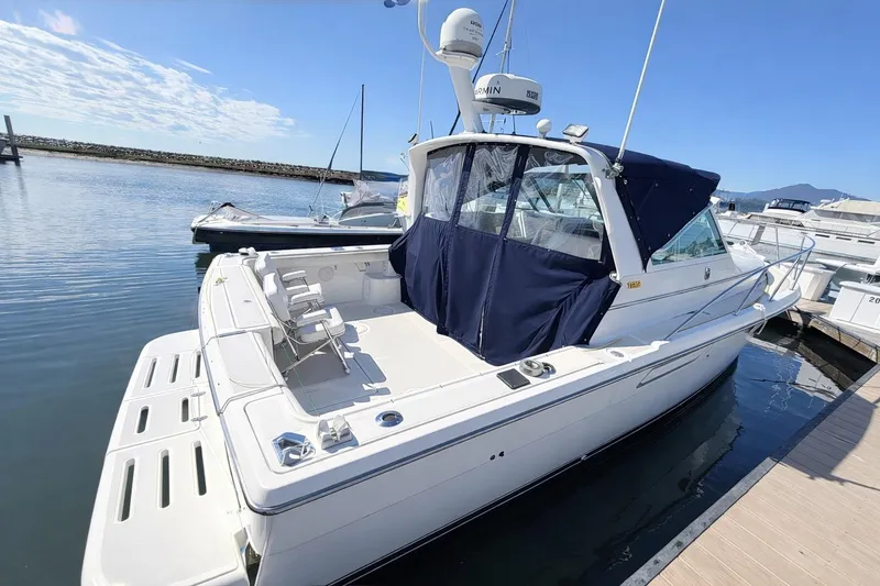 Slide: The Image of 1997 Tiara 3100 Open Express boat docked at marina under clear blue sky. - 3