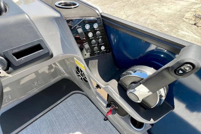 Slide: The Image of Control panel of 2026 Harris Sunliner 210 boat, featuring steering and switches. - 16