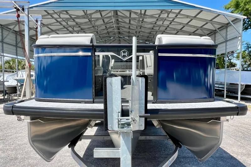 Slide: The Image of 2026 Harris Sunliner 210 pontoon boat in a covered storage area. - 3