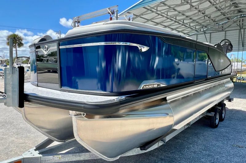 Slide: The Image of 2026 Harris Sunliner 210 pontoon boat on trailer under a metal canopy. - 4