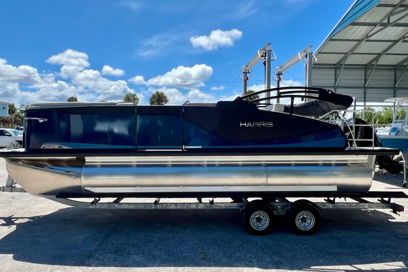 Slide: The Image of 2026 Harris Sunliner 210 pontoon boat on trailer under blue sky. - 5