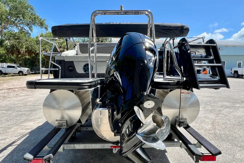 Slide: The Image of 2026 Harris Sunliner 210 pontoon boat with powerful outboard motor, parked outdoors. - 7
