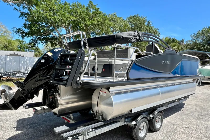 Slide: The Image of 2026 Harris Sunliner 210 pontoon boat on trailer, featuring sleek design and powerful outboard motor. - 8