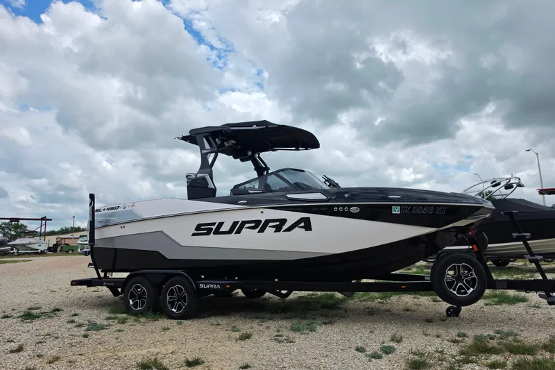 The Image of 2023 Supra SL 450 boat on trailer under cloudy sky, side view. - 1