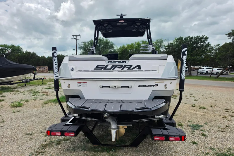 Slide: The Image of 2023 Supra SL 450 boat rear view with Texoma branding, parked outdoors. - 4
