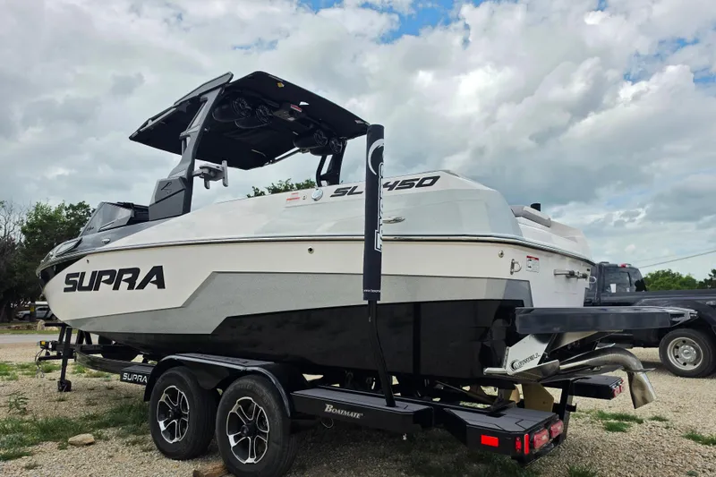 Slide: The Image of 2023 Supra SL 450 boat on trailer, under cloudy sky. - 5