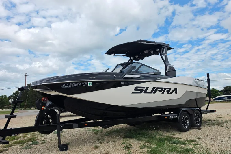 Slide: The Image of 2023 Supra SL 450 boat on trailer under cloudy sky. - 7