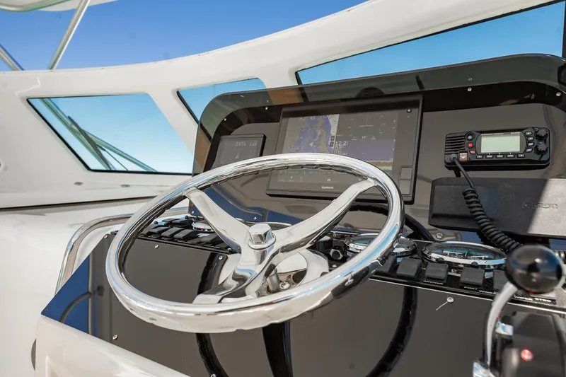 Slide: The Image of Helm of 2004 Luhrs Tournament 320 Open with steering wheel and navigation equipment. - 23