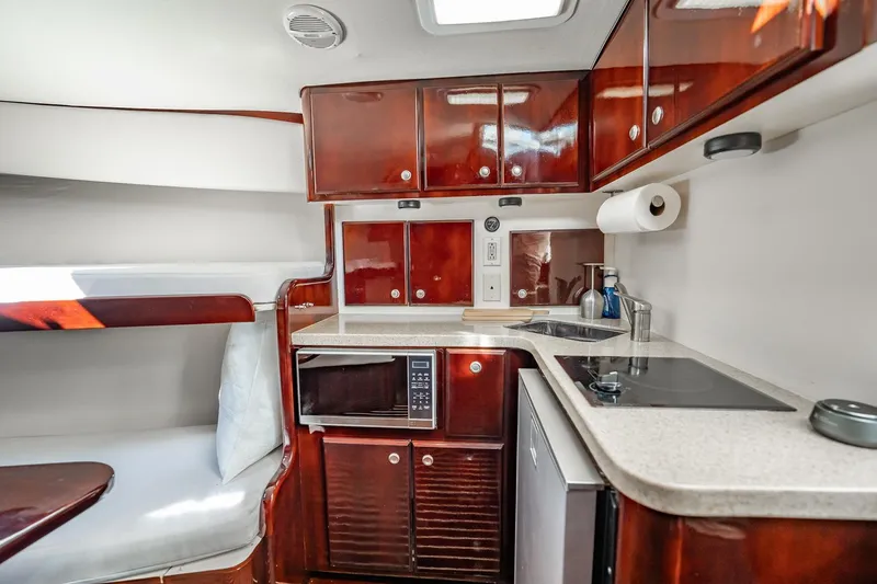 Slide: The Image of Luxurious 2004 Luhrs Tournament 320 Open yacht interior with kitchenette and wooden cabinetry. - 38