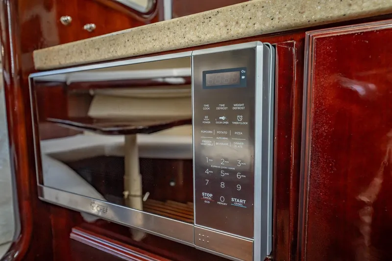 Slide: The Image of Microwave in 2004 Luhrs Tournament 320 Open yacht kitchen with wood cabinetry. - 41