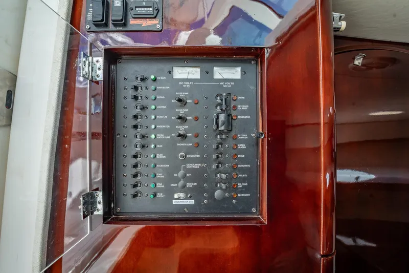 Slide: The Image of Electrical panel on a 2004 Luhrs Tournament 320 Open boat, featuring various switches and controls. - 42