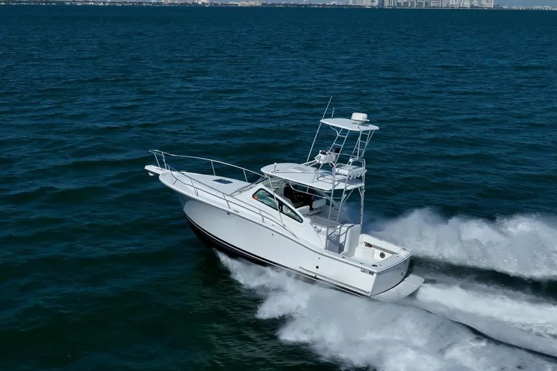 Slide: The Image of 2004 Luhrs Tournament 320 Open cruising on open water, creating a dynamic wake. - 49