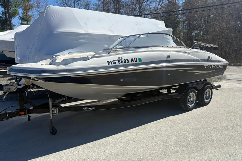 The Image of 2009 Tahoe 216 I/O WT boat on trailer, parked outdoors, side view. - 0