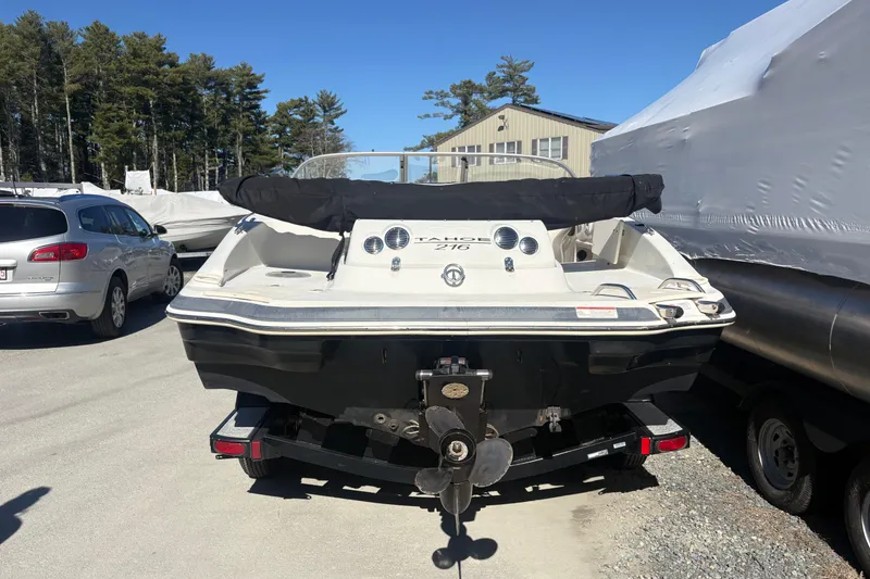 Slide: The Image of 2009 Tahoe 216 I/O WT boat on trailer, parked outdoors near other vehicles. - 1