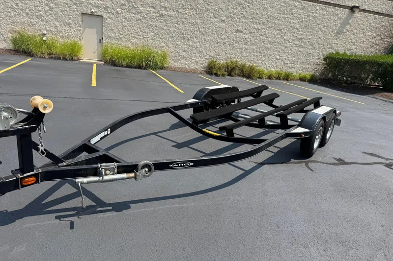 Slide: The Image of 2009 Tahoe 216 I/O WT boat trailer parked on asphalt near a building. - 10