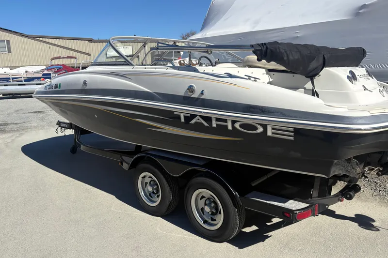 Slide: The Image of 2009 Tahoe 216 I/O WT boat on trailer, parked outdoors under clear sky. - 3