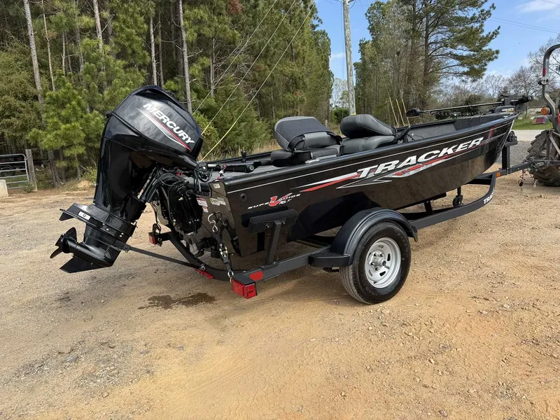 Slide: The Image of 2025 Tracker Super Guide V16 Tiller with Mercury 40 trailer outdoors. - 4