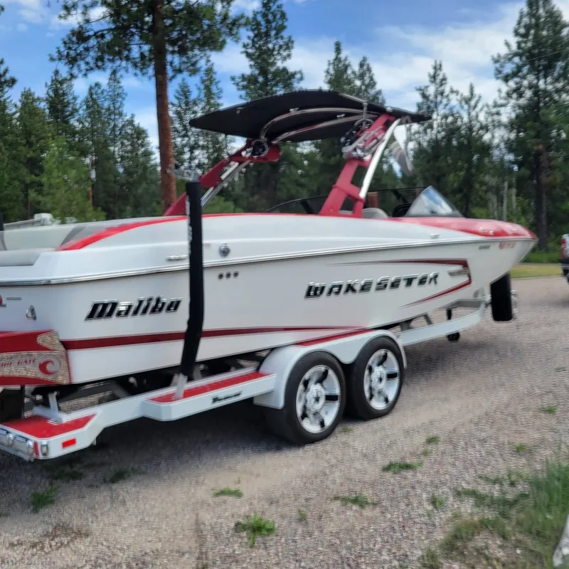 The Image of 2014 Malibu Wakesetter 24 MXZ boat on trailer outdoors. - 1