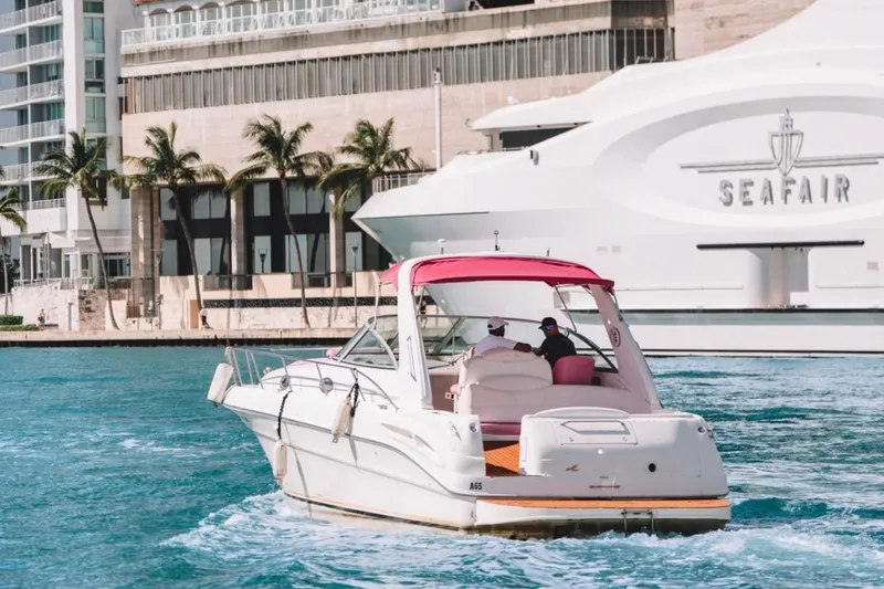 Slide: The Image of 2001 Sea Ray 360 Express Cruiser navigating vibrant waters near modern waterfront buildings. - 12