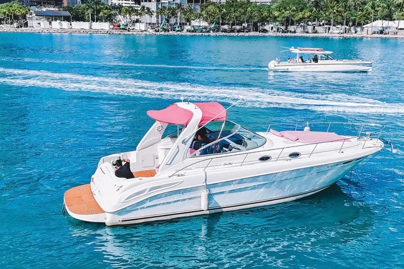 Slide: The Image of 2001 Sea Ray 360 Express Cruiser with pink canopy on clear blue water. - 3