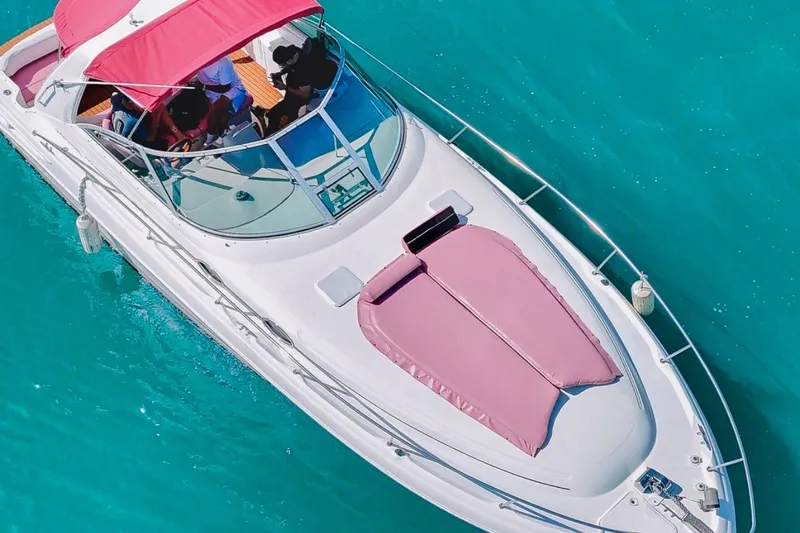 Slide: The Image of 2001 Sea Ray 360 Express Cruiser with pink canopy on turquoise water. - 7