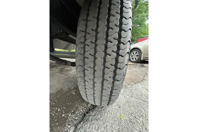 Slide: The Image of Close-up of a tire on a 2021 Tracker Pro Guide V-16 SC trailer. - 10