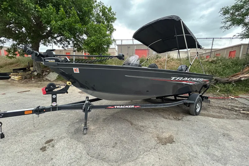 Slide: The Image of 2021 Tracker Pro Guide V-16 SC boat on trailer, parked outdoors under cloudy sky. - 14