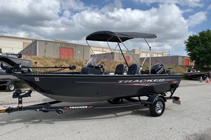 Slide: The Image of 2021 Tracker Pro Guide V-16 SC boat with canopy on trailer, parked outdoors. - 22