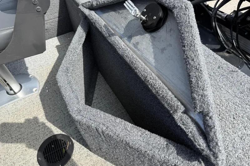 Slide: The Image of 2021 Tracker Pro Guide V-16 SC boat interior with carpeted storage compartment and seat base. - 28