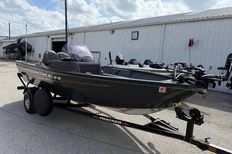 Slide: The Image of 2021 Tracker Pro Guide V-16 SC fishing boat on trailer, parked outside a warehouse. - 45