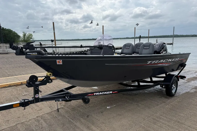Slide: The Image of 2021 Tracker Pro Guide V-16 SC boat on trailer by a lake, overcast sky. - 50