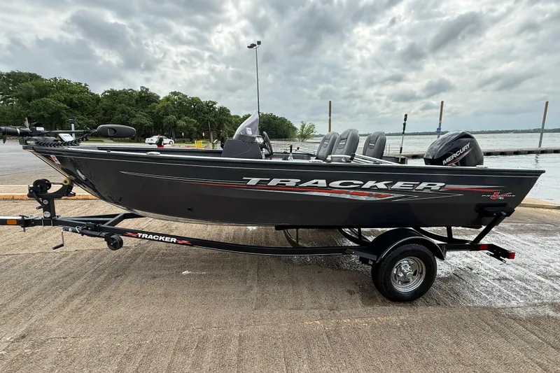 Slide: The Image of 2021 Tracker Pro Guide V-16 SC boat on trailer by a lake under cloudy skies. - 52