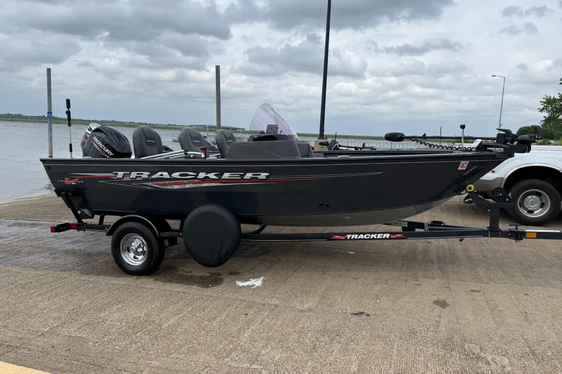 Slide: The Image of 2021 Tracker Pro Guide V-16 SC boat on trailer by a lake under cloudy skies. - 58