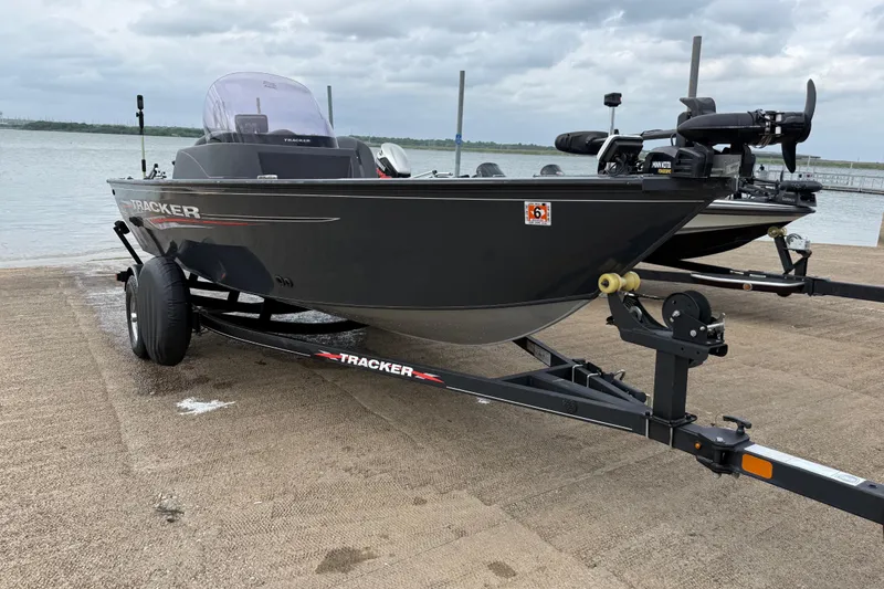 Slide: The Image of 2021 Tracker Pro Guide V-16 SC boat on trailer by the water. - 59