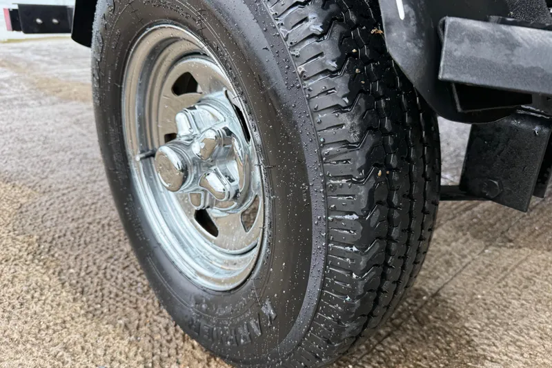 Slide: The Image of Close-up of a 2021 Tracker Pro Guide V-16 SC trailer tire on wet pavement. - 61