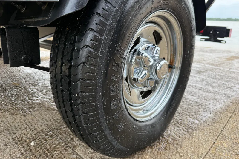 Slide: The Image of Close-up of a 2021 Tracker Pro Guide V-16 SC trailer tire on wet pavement. - 63