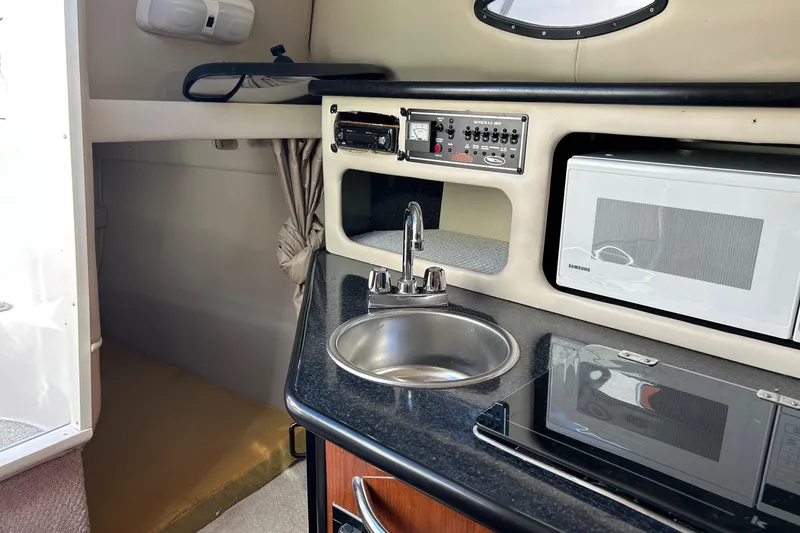 Slide: The Image of 2001 Chaparral Signature 240 interior with kitchenette, sink, microwave, and control panel. - 27